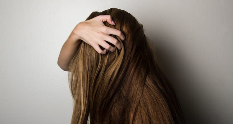 woman hand combing her long hair
